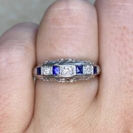 wedding band on hand with 4 sapphire stones and 3 white diamonds