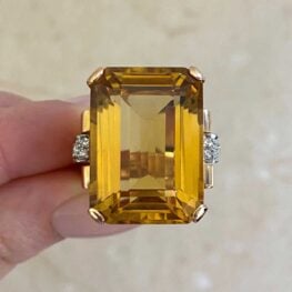 prong set citrine stone flankes by a ribbon design set with single cut diamonds