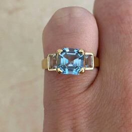 Asino Ring featuring a 1.32 carat asscher-cut aquamarine center that is prong-set